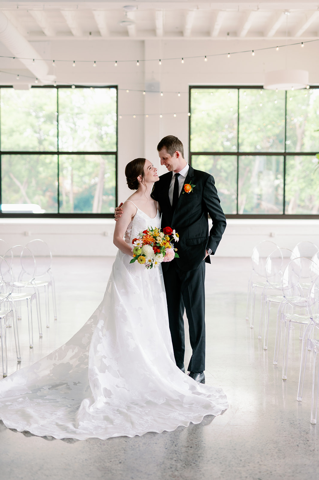 Newlyweds stand in their empty ceremony space in a white gown and black suit Unique Wedding Venues Minnesota