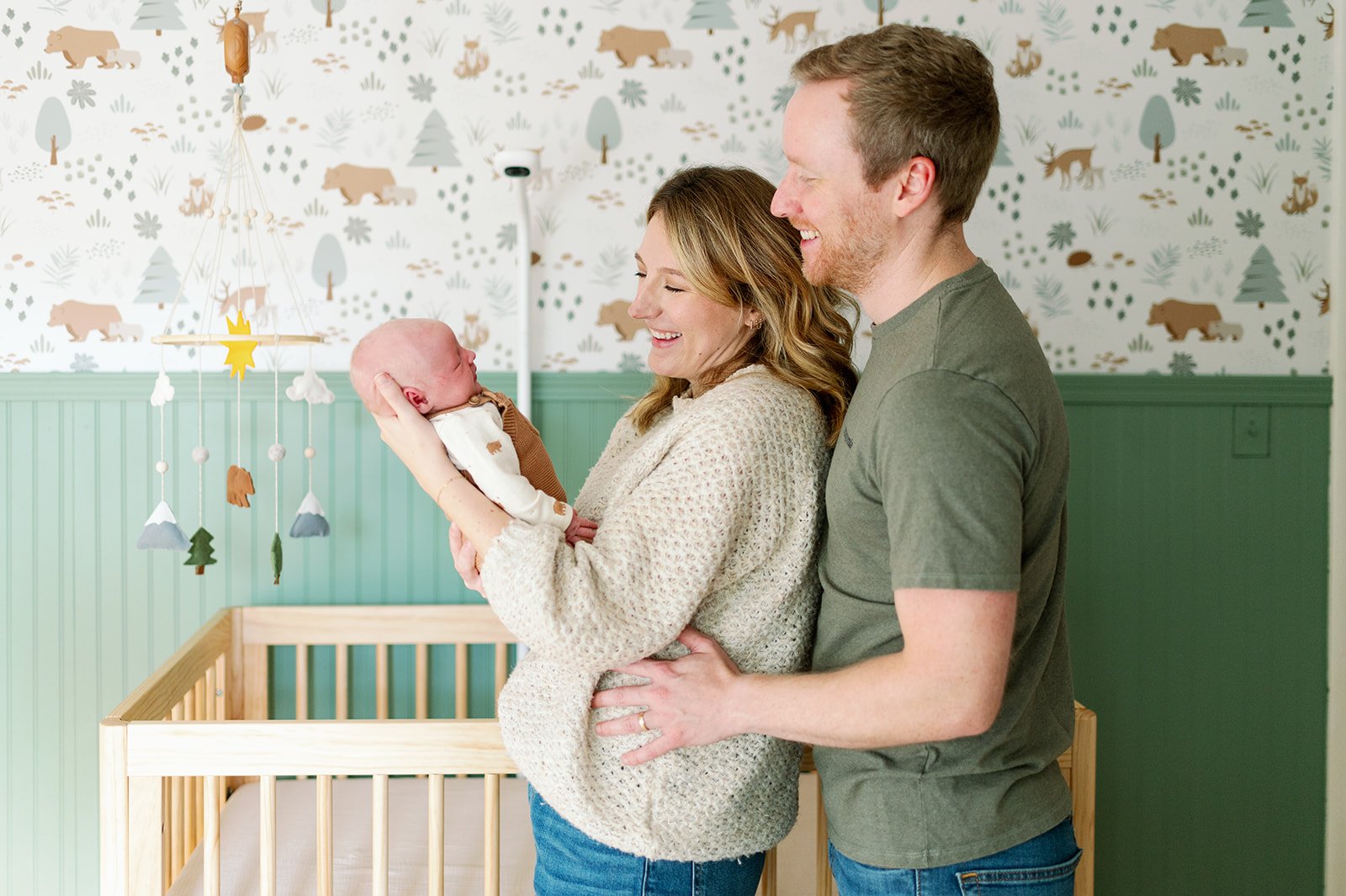 new parents holding and looking at newborn at in home newborn lifestyle session in MN