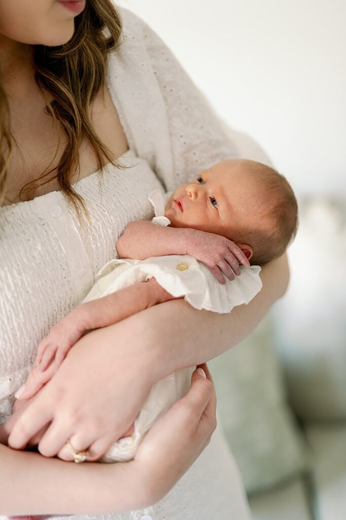 Close up of baby in mom's arms at in home newborn lifestyle session in MN