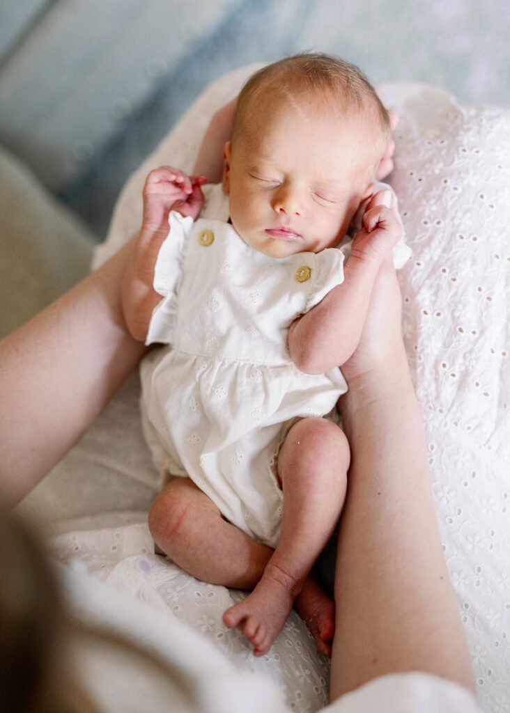 close up of newborn baby in mom's lap at their in home lifestyle newborn session in Minnesota