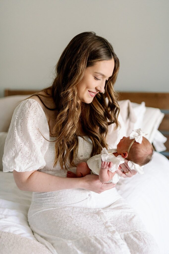 mom holding newborn baby at an in home lifestyle newborn session in Minneapolis