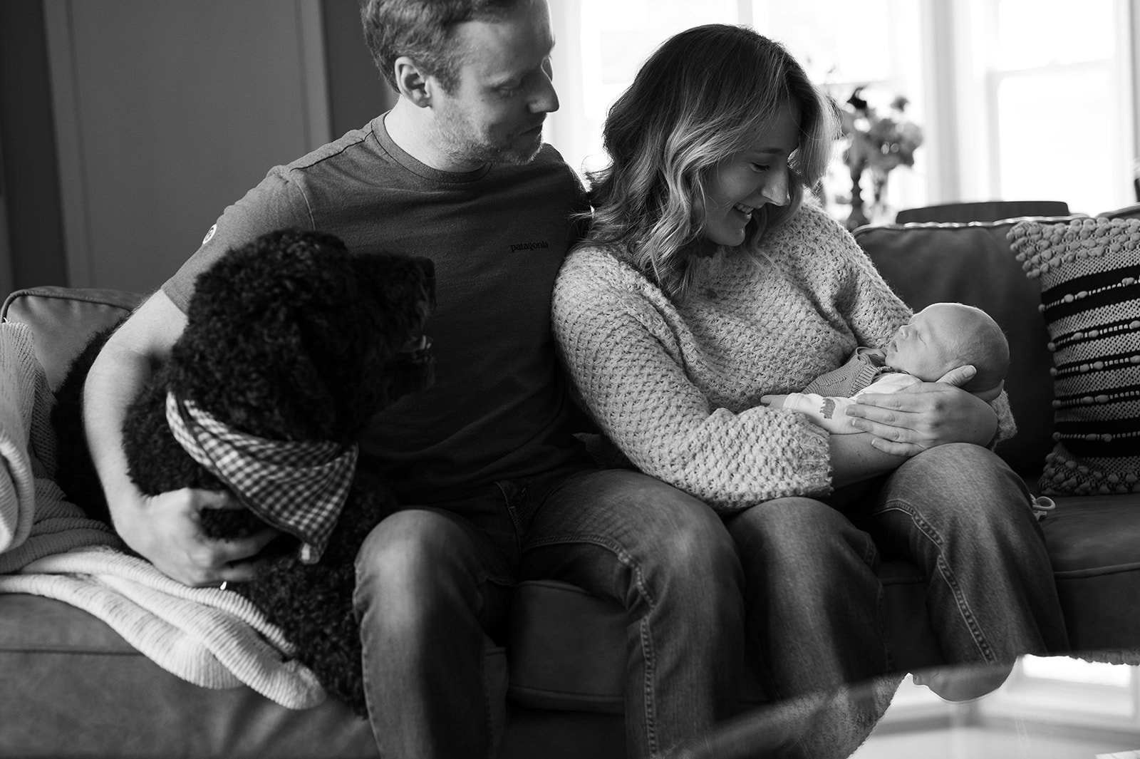 family looking at newborn baby to show in home lifestyle newborn session
