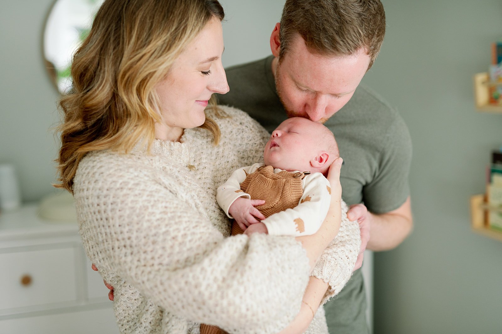 dad kissing newborn's head at in-home newborn session in MN