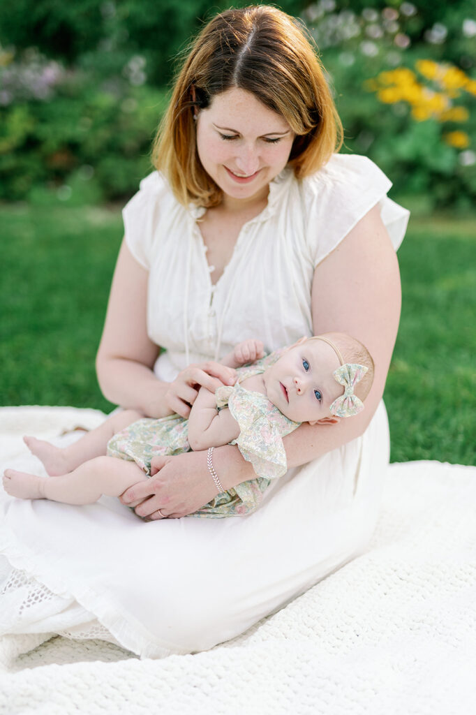 mom looking at newborn baby to show what to wear for newborn photos