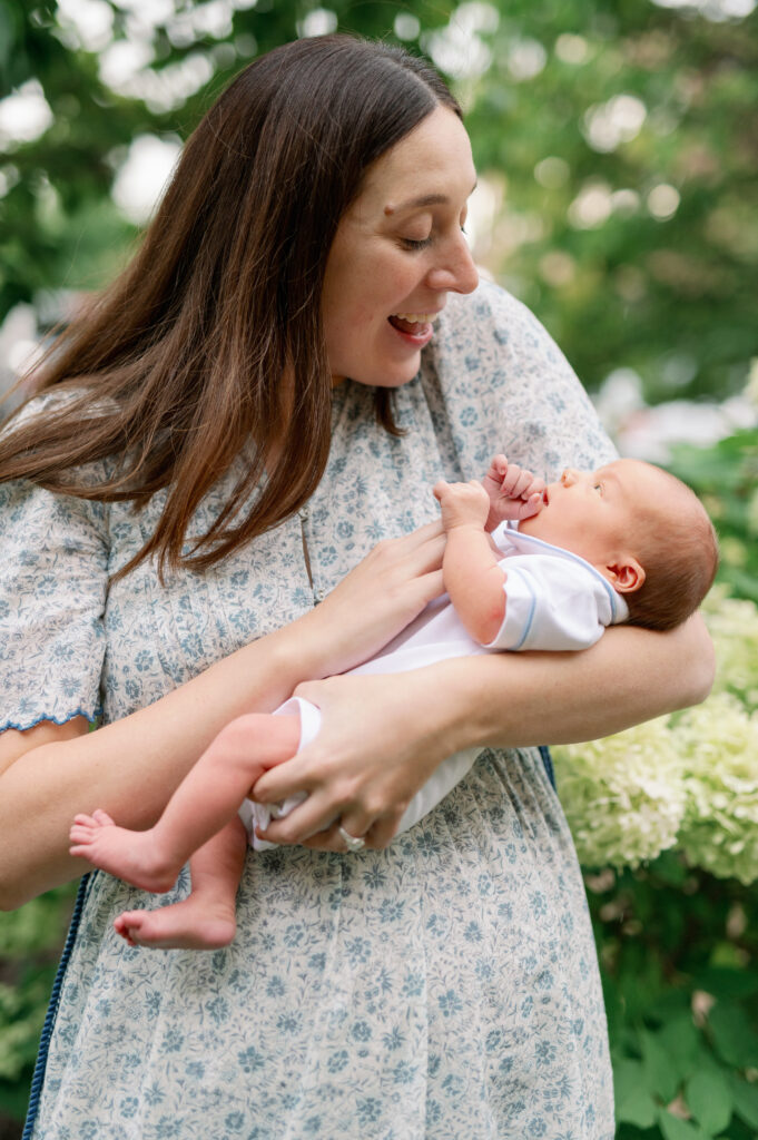 mom holding baby to show what to wear for newborn pictures