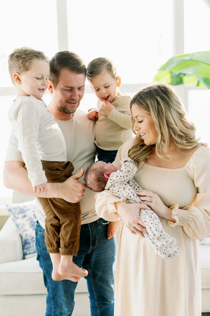 family looking at newborn baby to show what to wear for newborn photo shoot