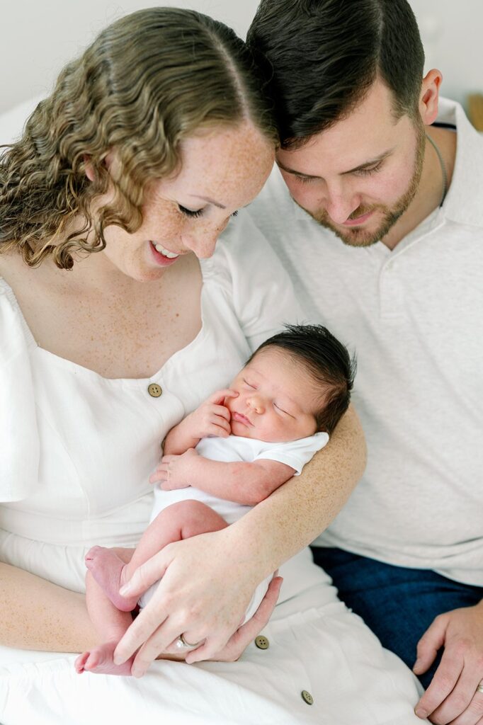 mother and father holding the baby in a newborn photoshoot