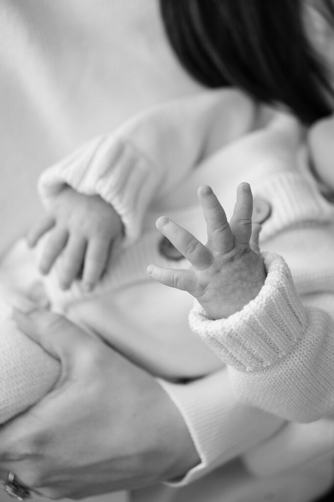 Best Time to Take Newborn Photos | Bauer Creative Black and white photo of tiny newborn fingers during the best time to take newborn photos.