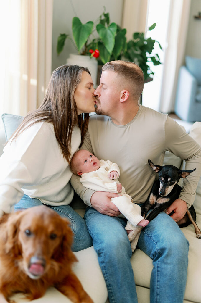 Best Time to Take Newborn Photos | Bauer Creative The best time to take newborn photos is when it works best for mom, dad and baby and all can relax on the couch like this couple with their newborn and pets.