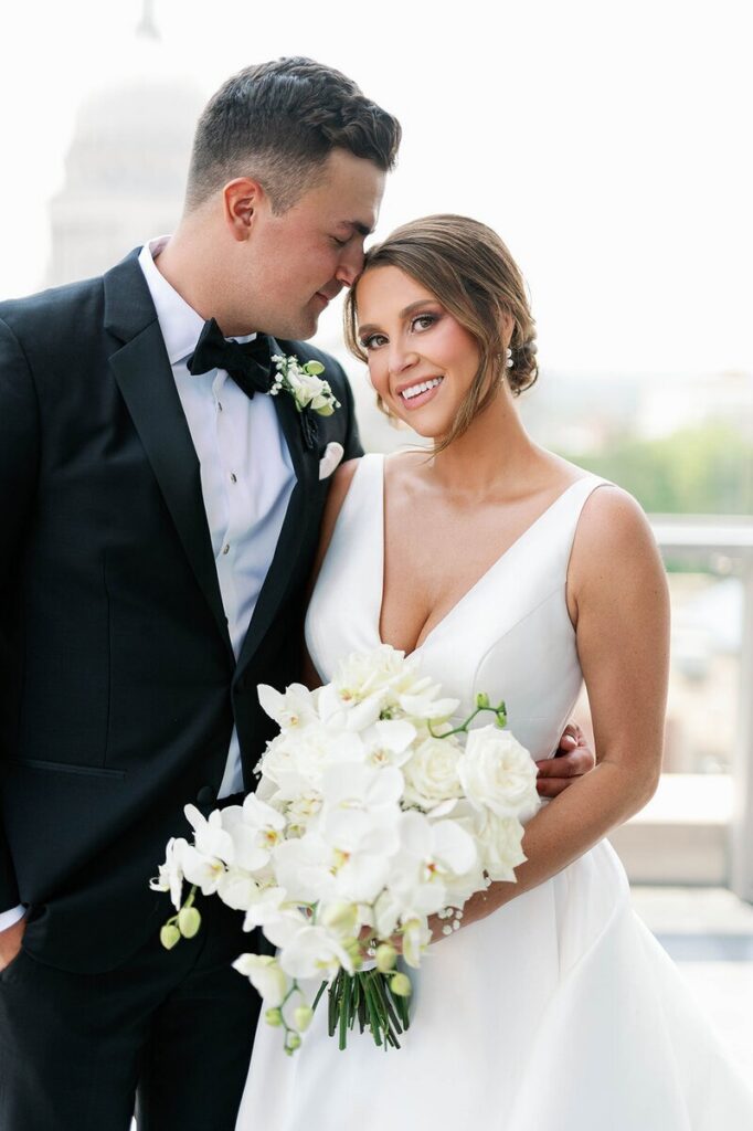 Minneapolis wedding photographer capturing a bride and groom sharing a close, intimate moment with a white bouquet. 