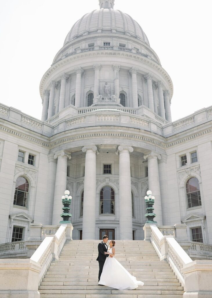 A wedding photographer in Minneapolis, MN capturing a couple standing together on grand steps in front of a historic building. 